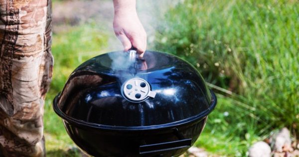 Chef hand holding the lid closed grill