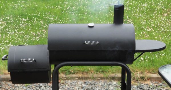 Charcoal offset smoker during backyard cookout